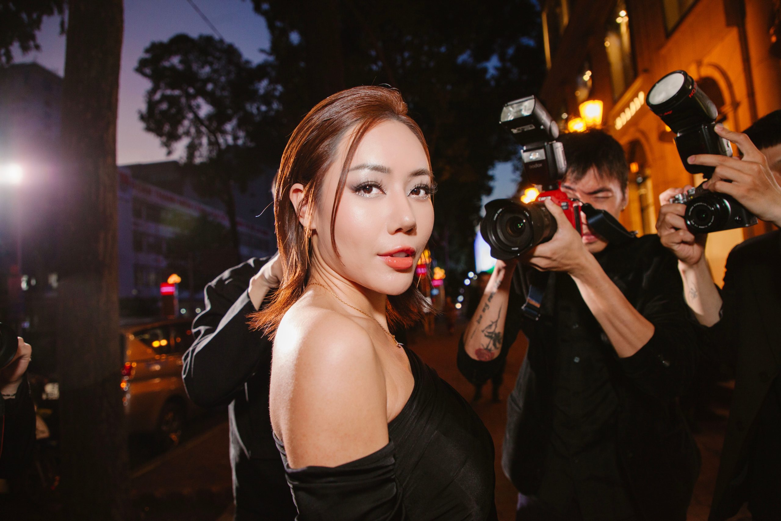 Glamorous celebrity posing for photographers at a night event, illustrating the spotlight stars face over Taiwan comments
