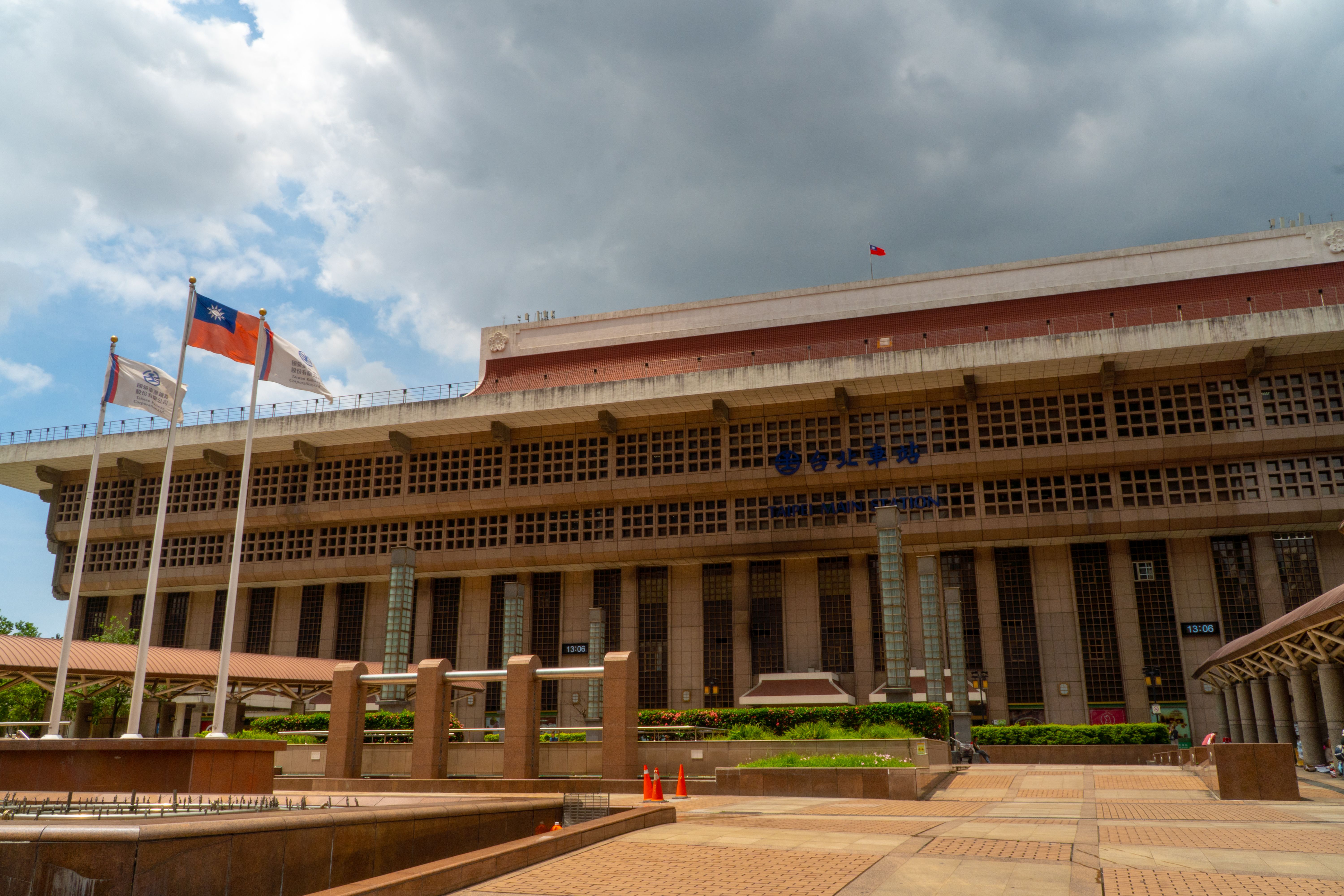 Taipei Main Station facade with Taiwanese flags waving, representing the Taiwan controversy