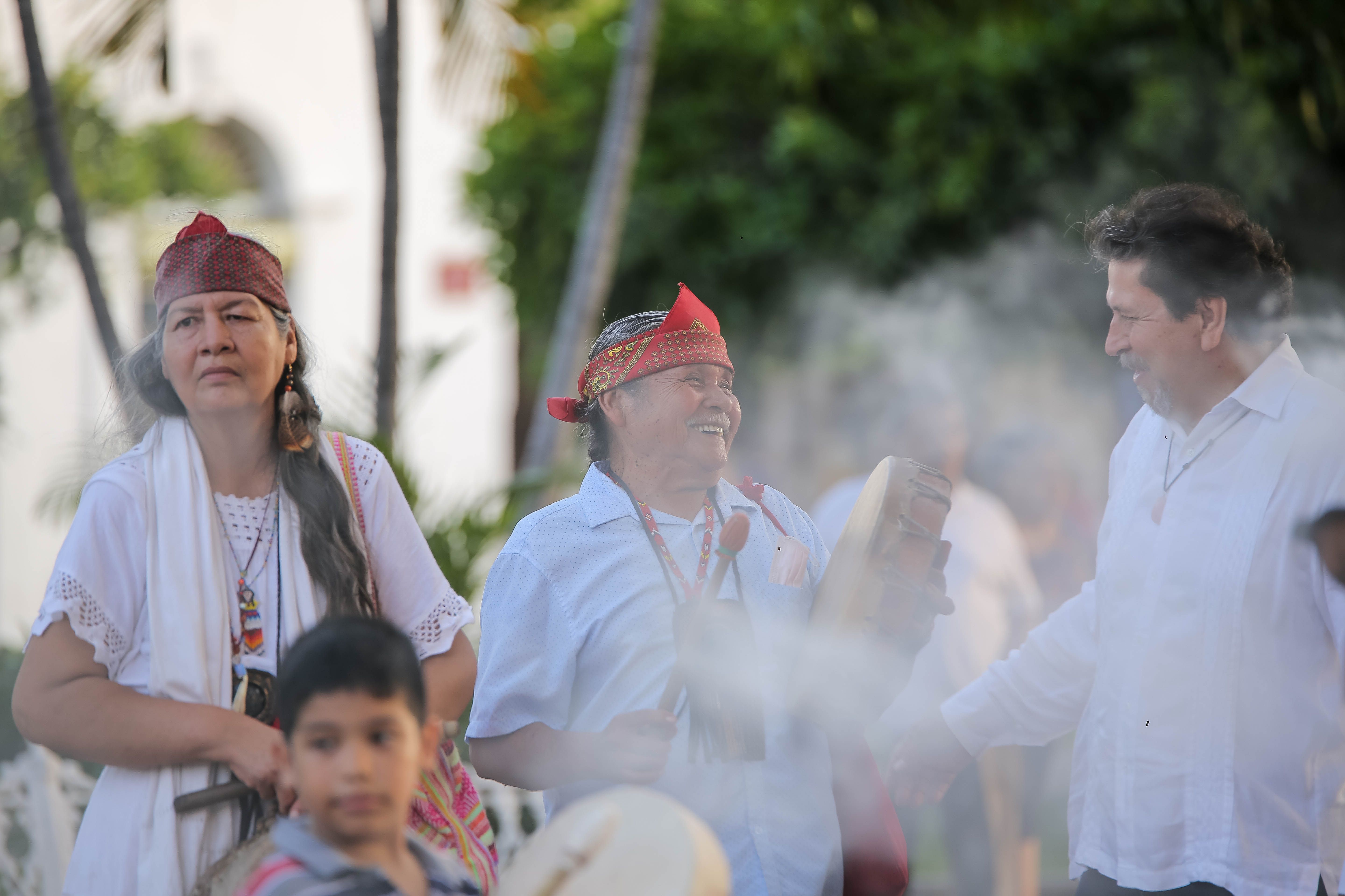 People drumming outdoors at a joyful cultural celebration